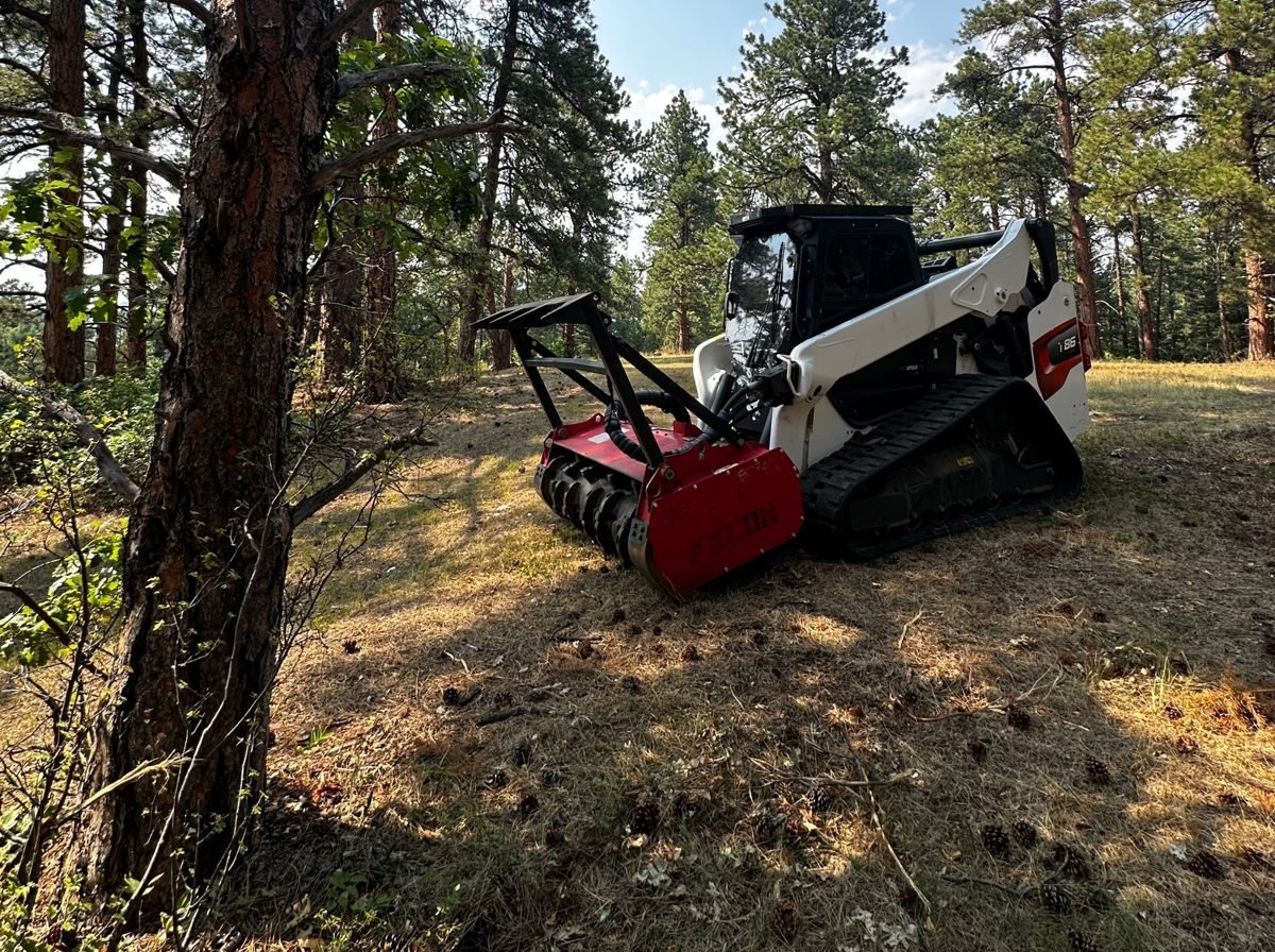 Bobcat T86 compact track loader with a forestry mulching head clearing dense brush on a Jefferson County WUI Overlay property